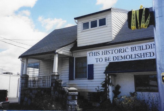 Rose Biggi's farmhouse with a sign reading "This historic building to be demolished."