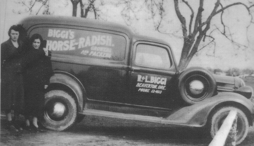Rose Biggi and family member standing next to car reading "Biggi's Horse-Radish"